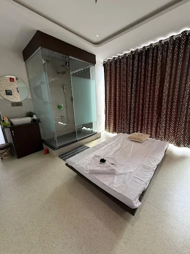Treatment room at Aurum Spa, Kharadi, with a glass steam and shower cabin