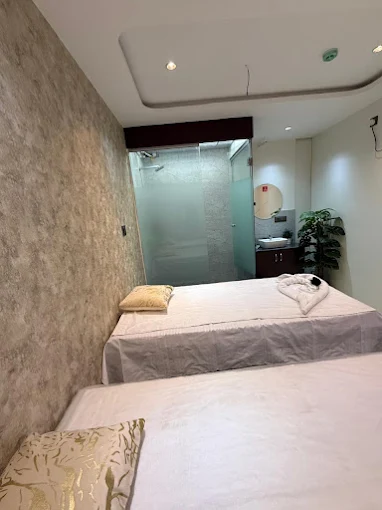 Massage treatment room at Aurum Spa, Kharadi, with two beds and an en-suite shower